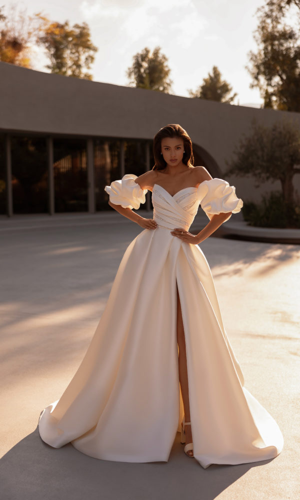 robe de mariée Demetrios 1520 avec bustier drapé et manches volumineuses, jupe fendue et silhouette moderne en extérieur