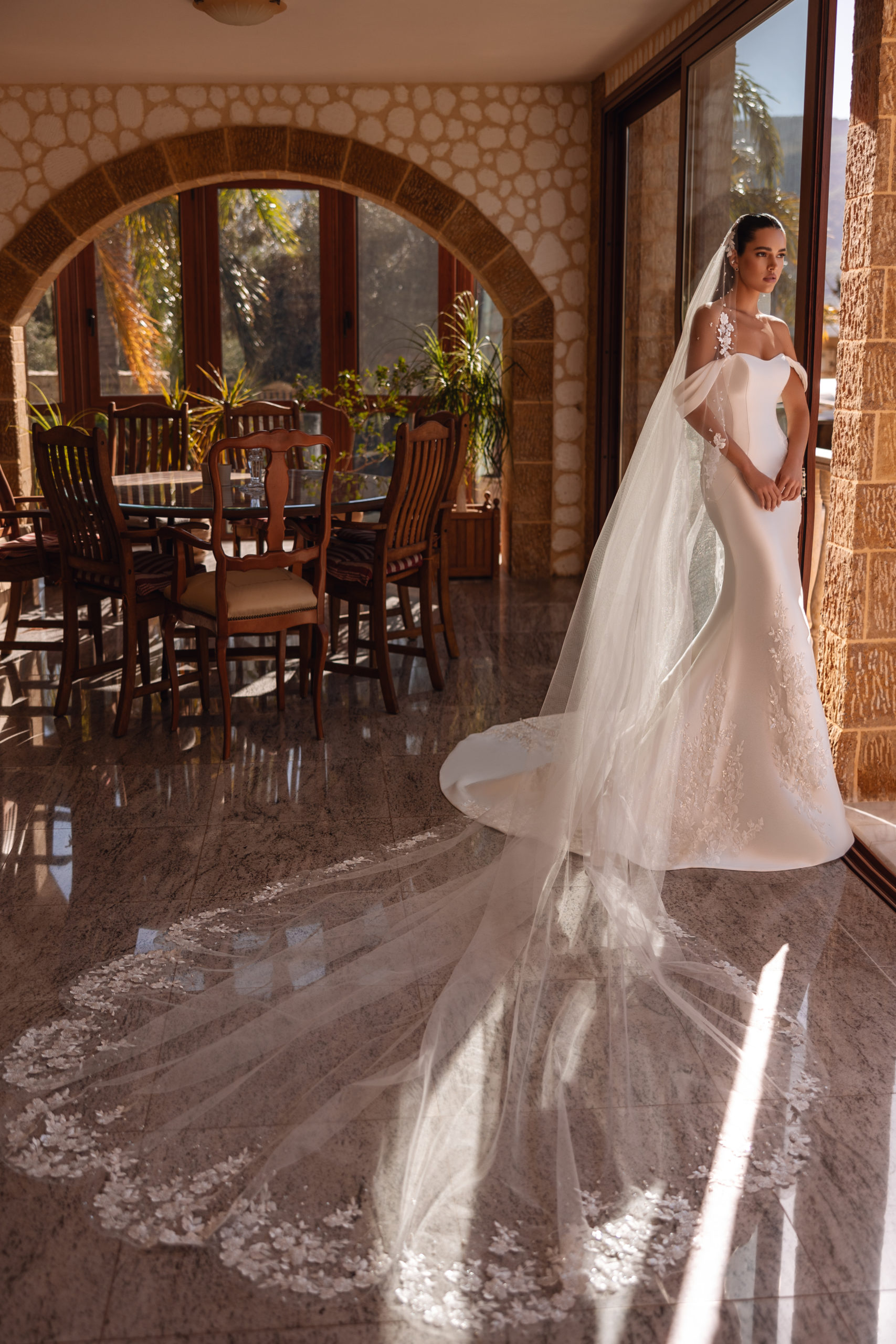 robe de mariée Cosmobella 8257 en coupe sirène, bustier cœur et broderies florales, photo en terrasse avec palmiers