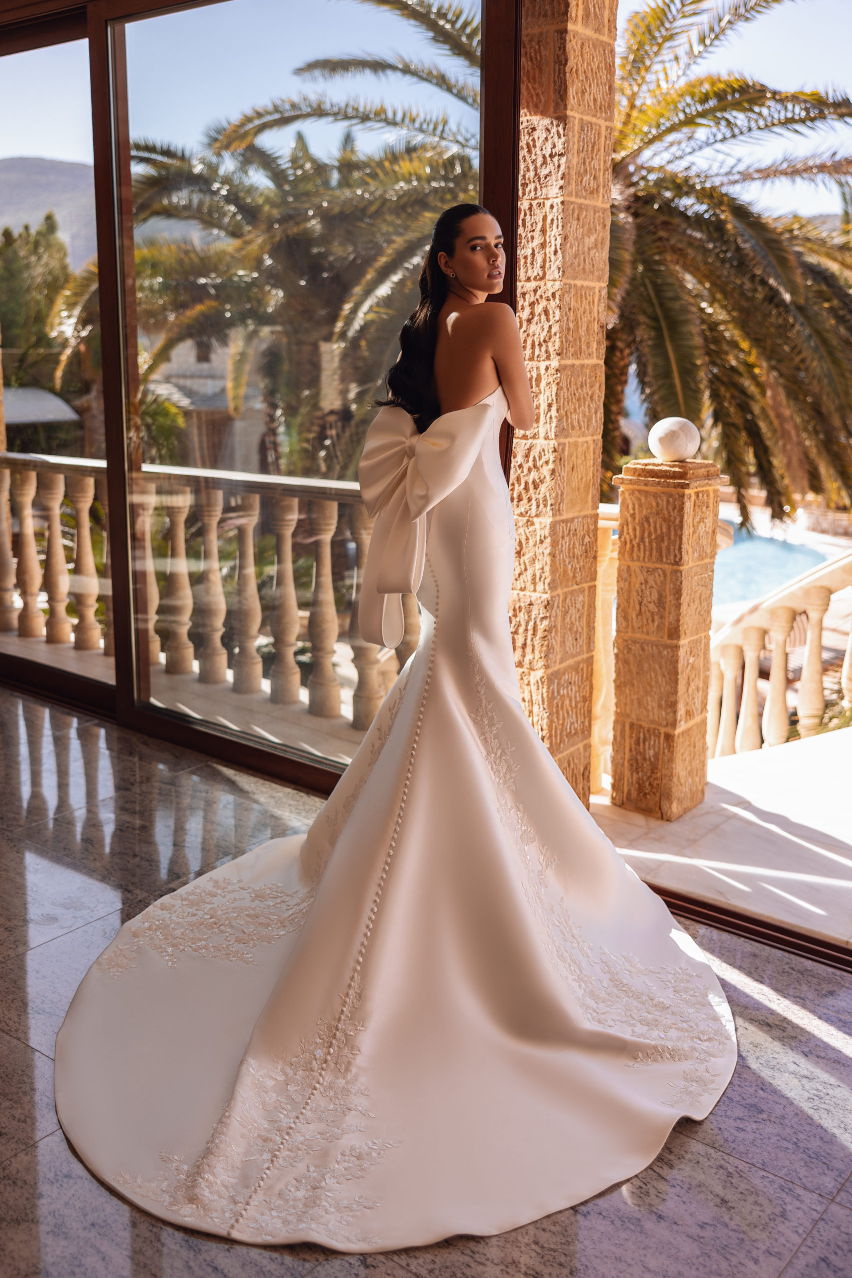 robe de mariée Cosmobella 8257 en coupe sirène, bustier cœur et broderies florales, photo en terrasse avec palmiers