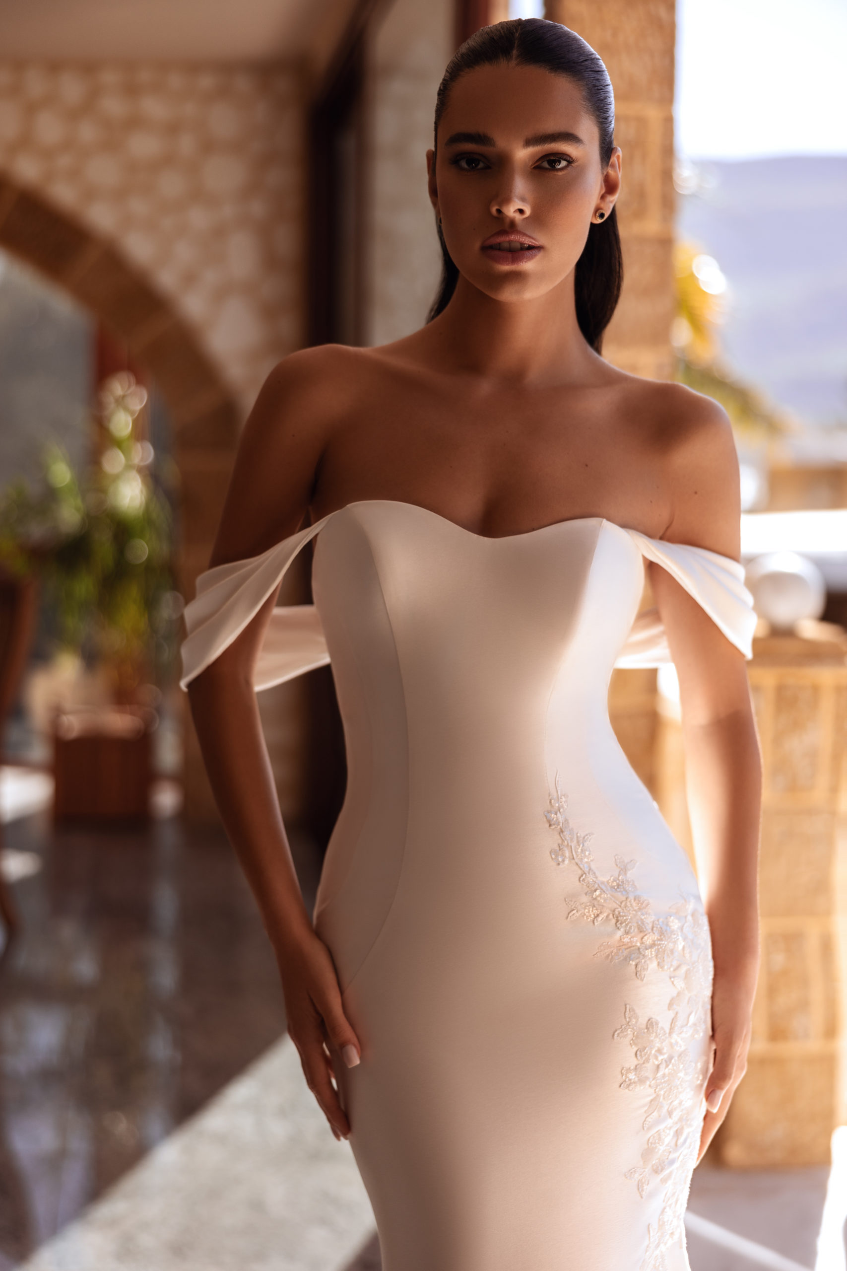 robe de mariée Cosmobella 8257 en coupe sirène, bustier cœur et broderies florales, photo en terrasse avec palmiers