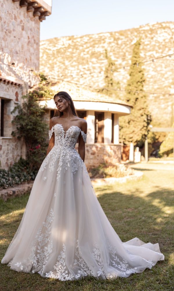 Robe de mariée Cosmobella 8312 à décolleté en cœur, épaules dégagées et jupe ample à motifs floraux.